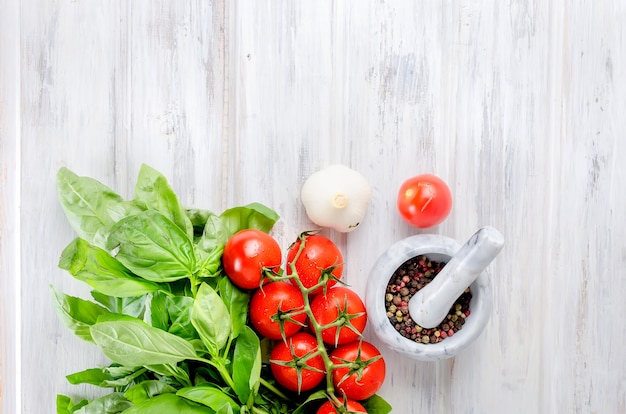 Tomatoes,  green basil and Spices in a stone mortar 