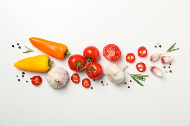 Tomatoes and ingredients on white background, top view