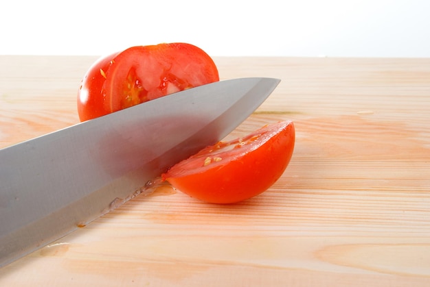 Pomodori e coltello su tavolo di legno