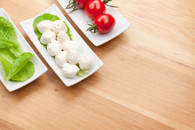 Tomatoes mozzarella and green salad leaves