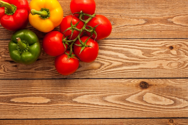 Tomatoes and peppers on a wooden background