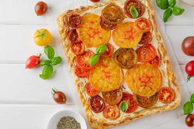 写真 パフケーキとチーズの ⁇ め物から作られたトマトパイまたはガレット ベジタリアン健康食品 選択的な焦点