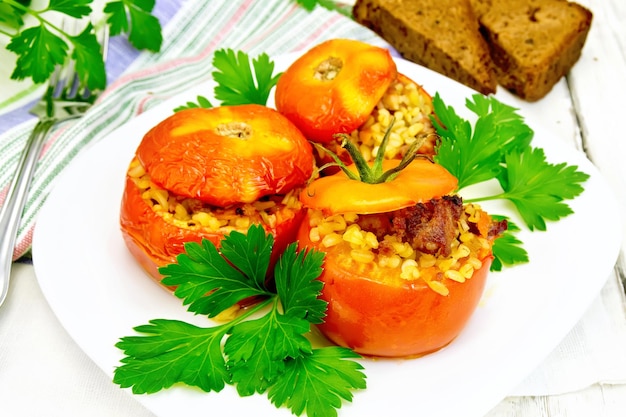 Tomatoes stuffed with bulgur and parsley in plate on light boar