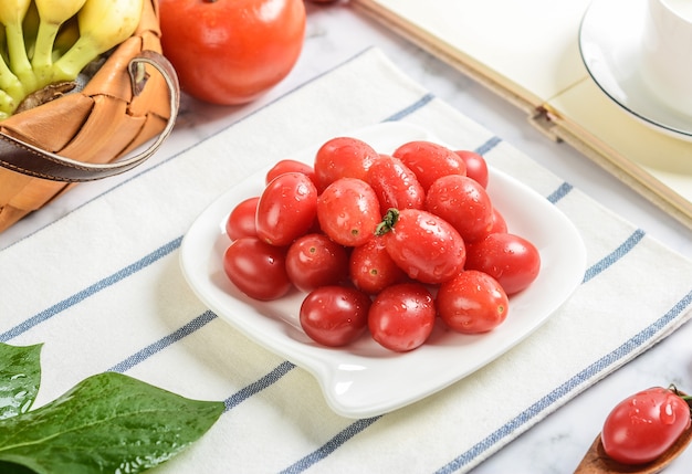 Tomatoes variety in a handmade tray with lettuce side view on wooden