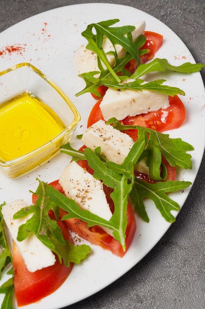 Tomatoes with cheese, arugula and honey. vertical frame