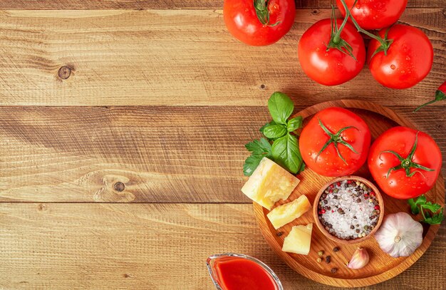 Tomatoes with ingredients for cooking. Italian cuisine concept. Top view, copy space.