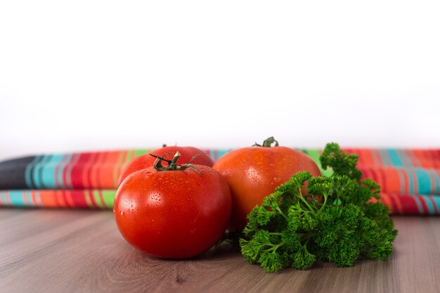 Foto pomodori su un tavolo di legno con tovaglia