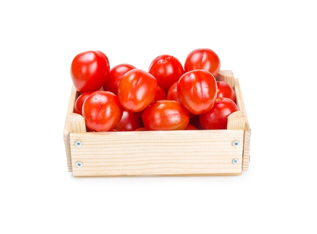 Tomatoes in a wooden box isolated on white background