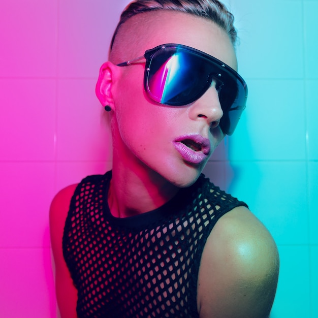 Tomboy Girl with short hair and luxury sunglasses. Fashion Party Style Clubbing neon light