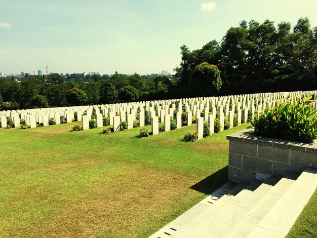 Photo tombstones against sky at cemetery on sunny day