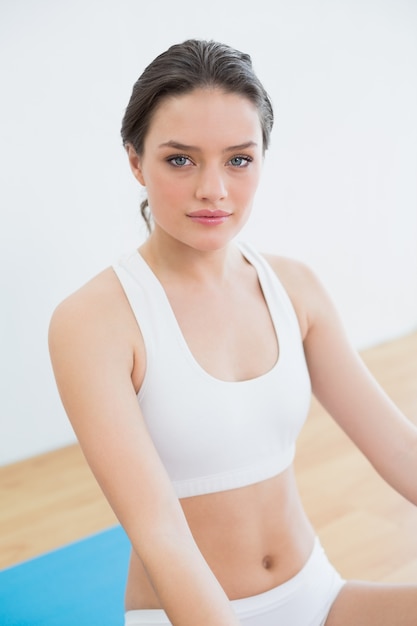 Toned brunette sitting at fitness studio