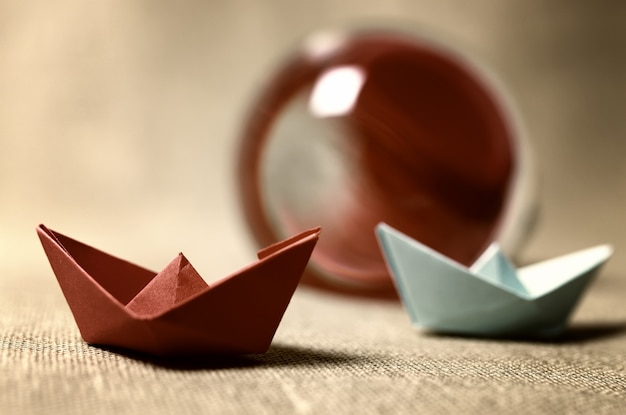 Toned colored paper boats glass