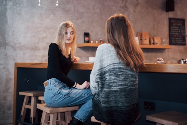Тонированное изображение лучших друзей, имеющих дату в кафе или ресторане. красивые девушки разговаривают или общаются за чашкой кофе