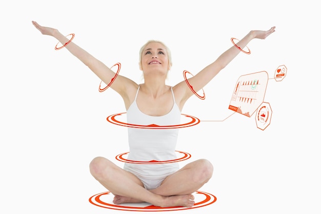 Toned young woman sitting with arms outstretched against fitness interface