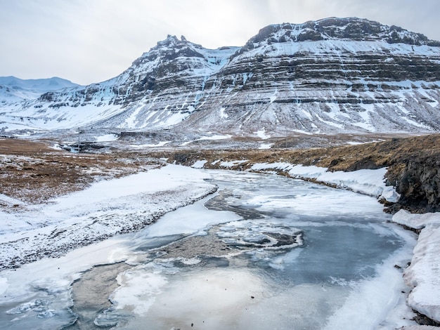Toneelmening rond Kirkjufellfoss-waterval in het noorden van IJsland en gladde ijsvijver