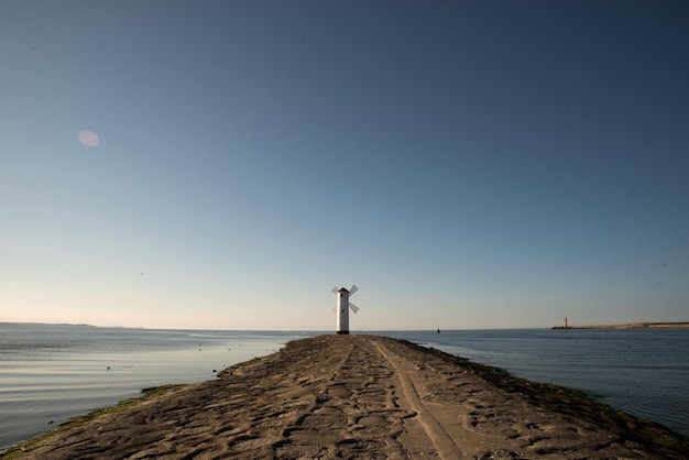 Toneelmening van de oude molenvuurtoren bij zonsopgang Swinoujscie Polandlighthouse mill