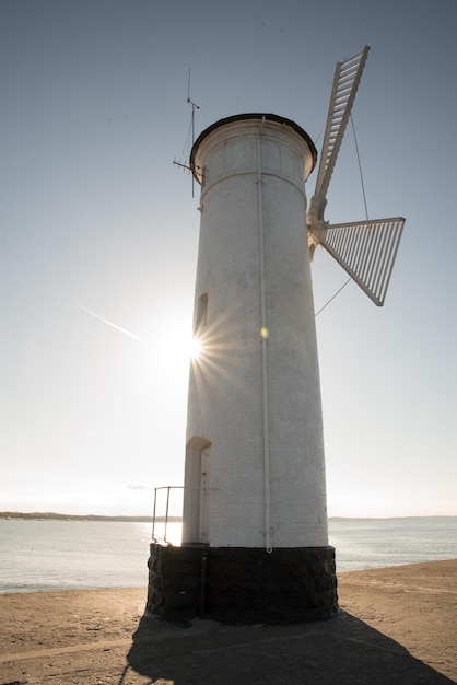 Toneelmening van de oude molenvuurtoren bij zonsopgang Swinoujscie Polandlighthouse mill