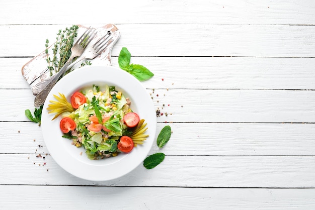 Tonijnsalade en verse groenten op een witte houten achtergrond Vrije ruimte voor uw tekst Bovenaanzicht