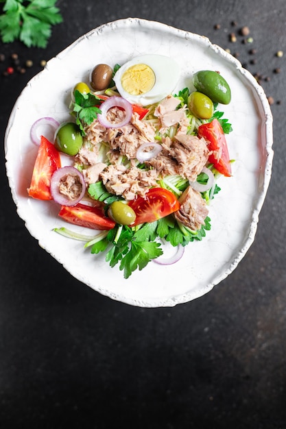 tonijnsalade groenten tomaat ui kruiden olijven andere tonijn uit blik zeevruchten op tafel