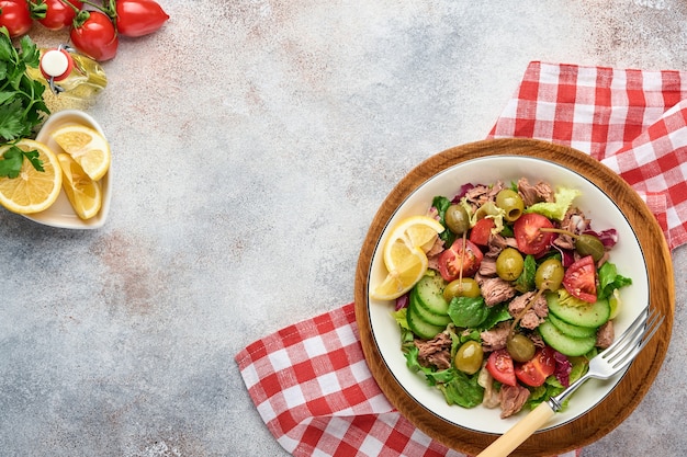 Tonijnsalade met verse groenten, olijven, kappertjes en citroen geserveerd in bowl