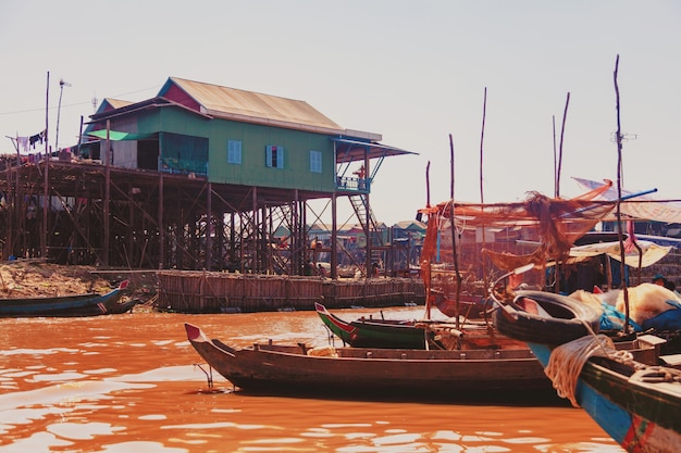 Озеро тонлесап. плавучая рыбацкая деревня кампонг пхлюк в сезон засухи. дома на сваях, люди и лодки. бедная страна. жизнь и работа жителей камбоджи на воде, недалеко от сиемреапа, камбоджа