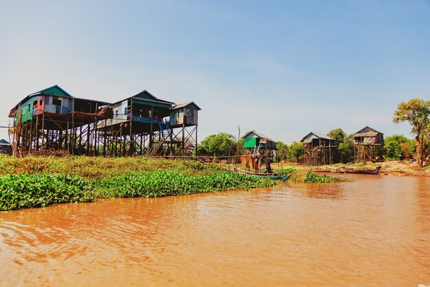 Tonlé Sap-meer. Kampong Phluk drijvend vissersdorp tijdens het droogteseizoen. Huizen op palen, mensen en boten. Arm land. Levens- en werkbewoners Cambodjaans op het water, nabij Siem Reap, Cambodja