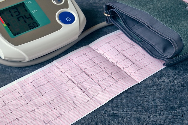 Тонометр и электрокардиограмма при работе сердца крупным планом с малой глубиной резкости