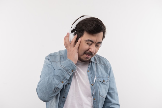 Too loud. Nice adult man wearing headphones while listening to music