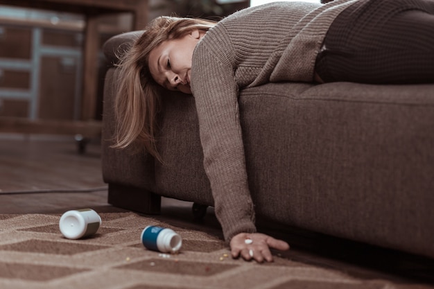 Too many pills. blonde-haired mature family woman falling\
asleep after taking too many pills