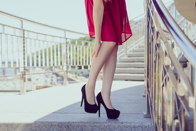 Too small big shoes beauty black red short outfit medical condition spasm muscle concept. Close up low angle view photo portrait of pretty nice elegant lady holding leg massaging the place