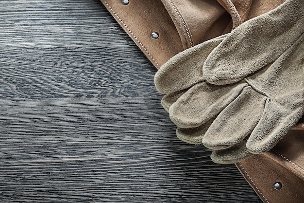 Tool belt leather safety gloves on wooden board