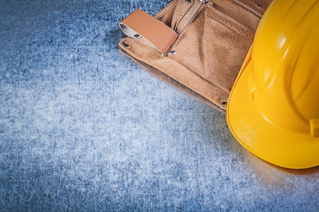 Tool belt safety hard hat on metallic background construction concept