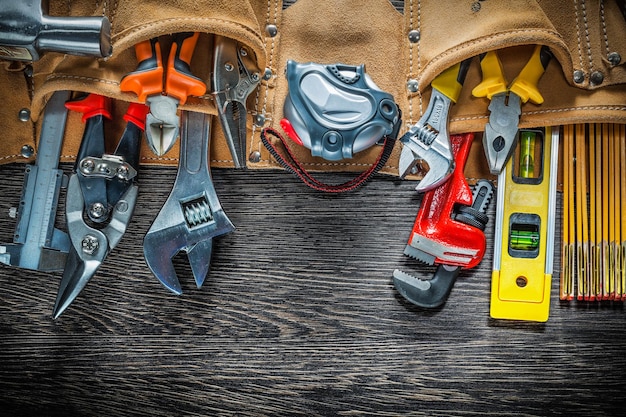 Foto cintura porta attrezzi con attrezzatura da costruzione su tavola di legno