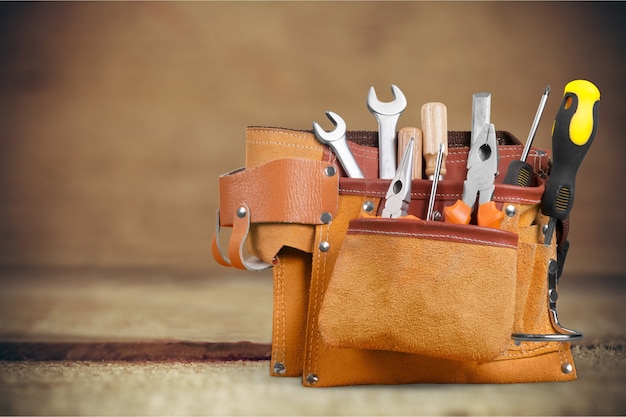 Tool belt with tools on wooden background