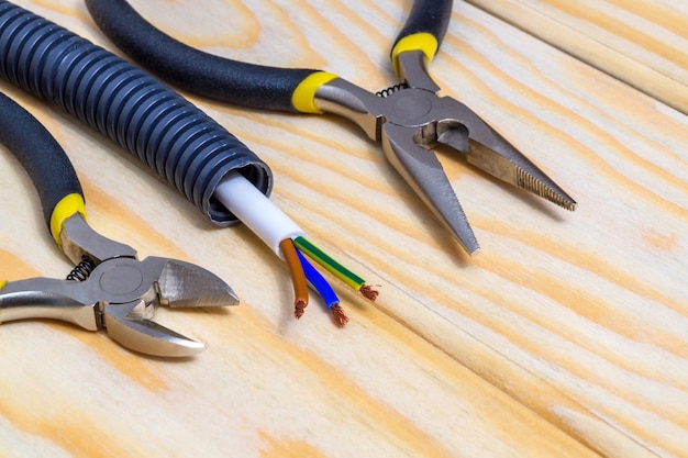 Инструмент и провода для электрики подготовлены перед ремонтом или установкой на деревянные доски