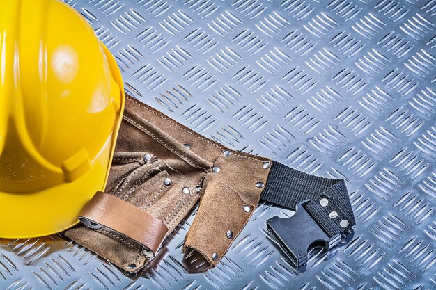 Toolbelt hard hat on corrugated metal background construction concept