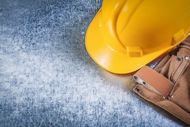 Toolbelt hard hat on metallic background construction concept