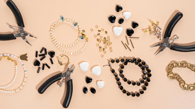 Tools and accessories for DIY jewelry in the workplace Flat lay on beige background