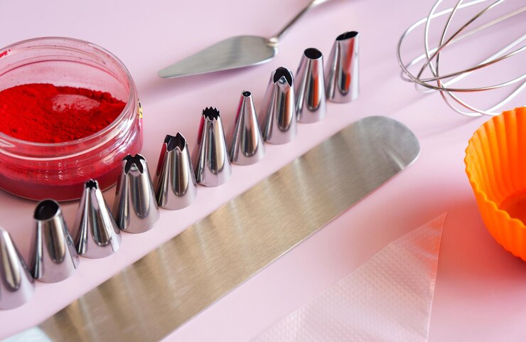 Tools for creating and decorating a cake various spatulas and cream nozzles for text and recipes on a purple background