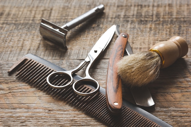 Foto strumenti per il taglio di barba barbiere su fondo in legno.