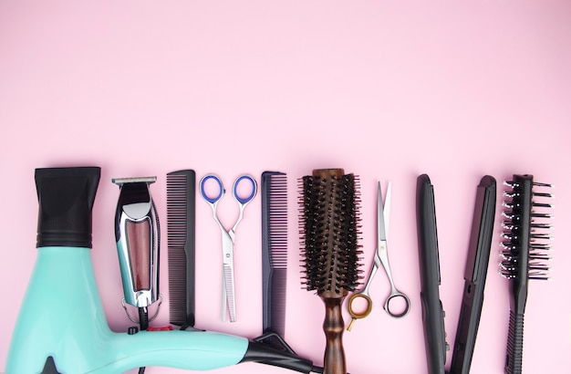 Tools for cutting and styling hair on a pink background