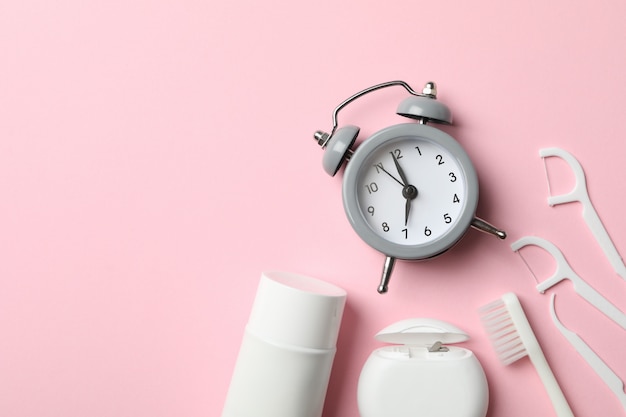 Tools for dental care on pink background, top view