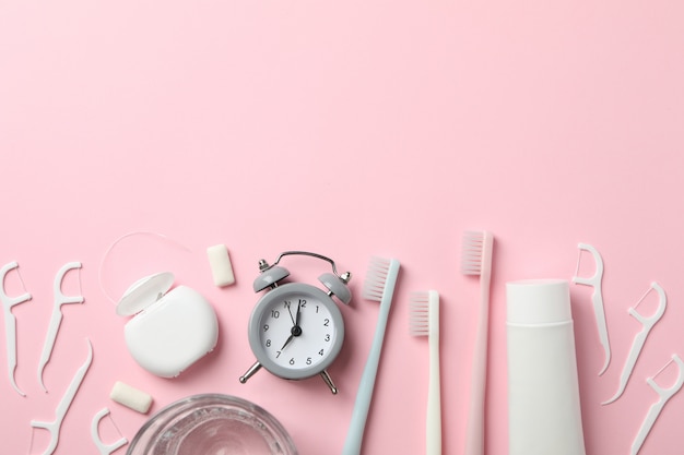 Tools for dental care on pink background, top view