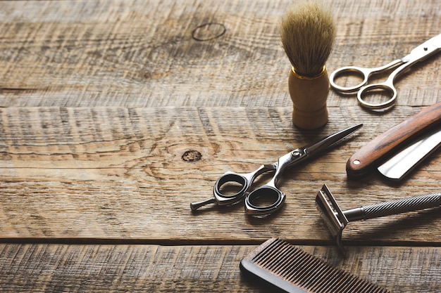 Фото Инструменты для стрижки бороды парикмахерской на деревянных фоне.
