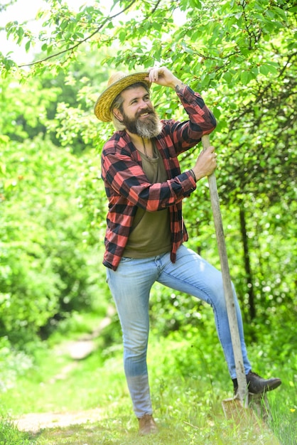 Tools for gardening Garden tools every gardener should have Look after them and store them carefully Gardener agricultural worker with garden tools Caucasian farmer countryside nature background