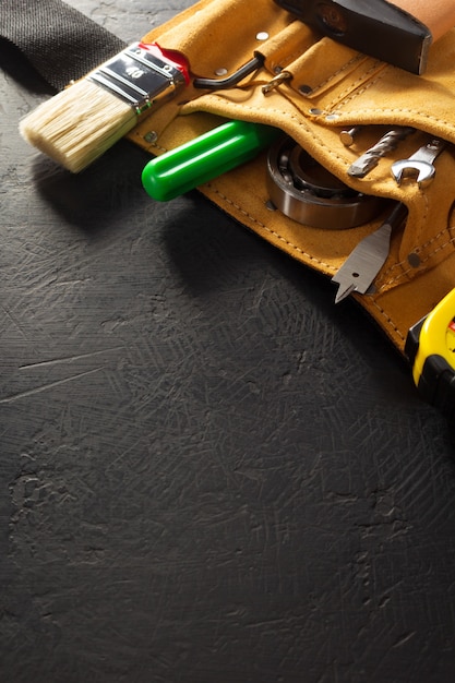 Tools and instruments in belt on black background