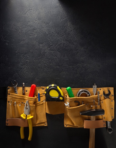 Tools and instruments in belt on black background