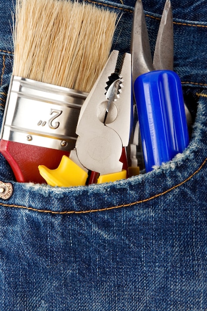 Инструменты и инструменты в кармане синих джинсов