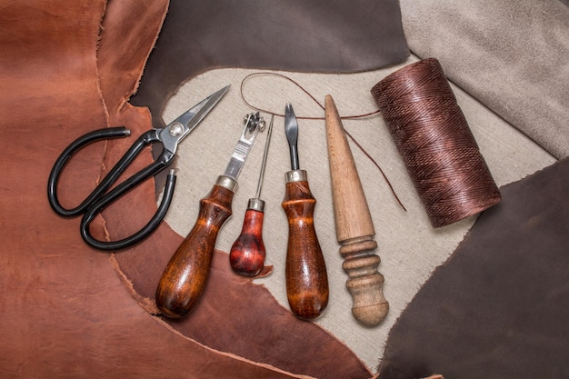 Tools for leather crafting and pieces of brown leather