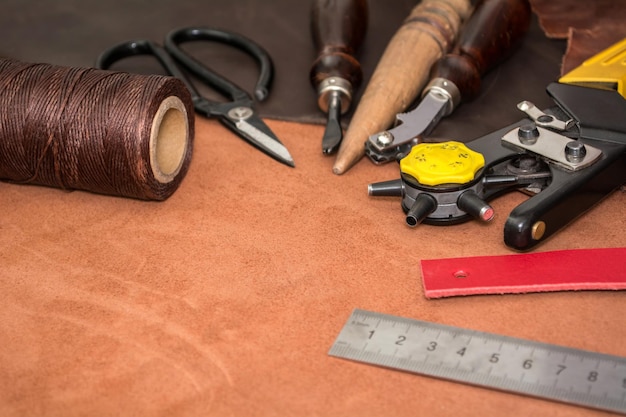 Tools for leather crafting and pieces of brown leather